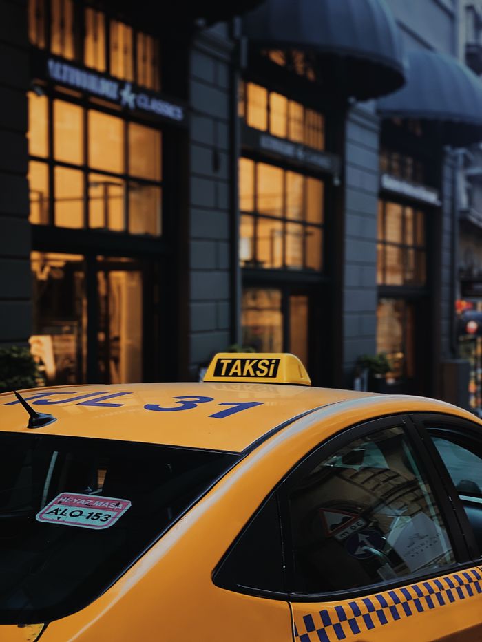 gallery-5 A yellow taxi parked on a lively street in Istanbul, capturing urban atmosphere.