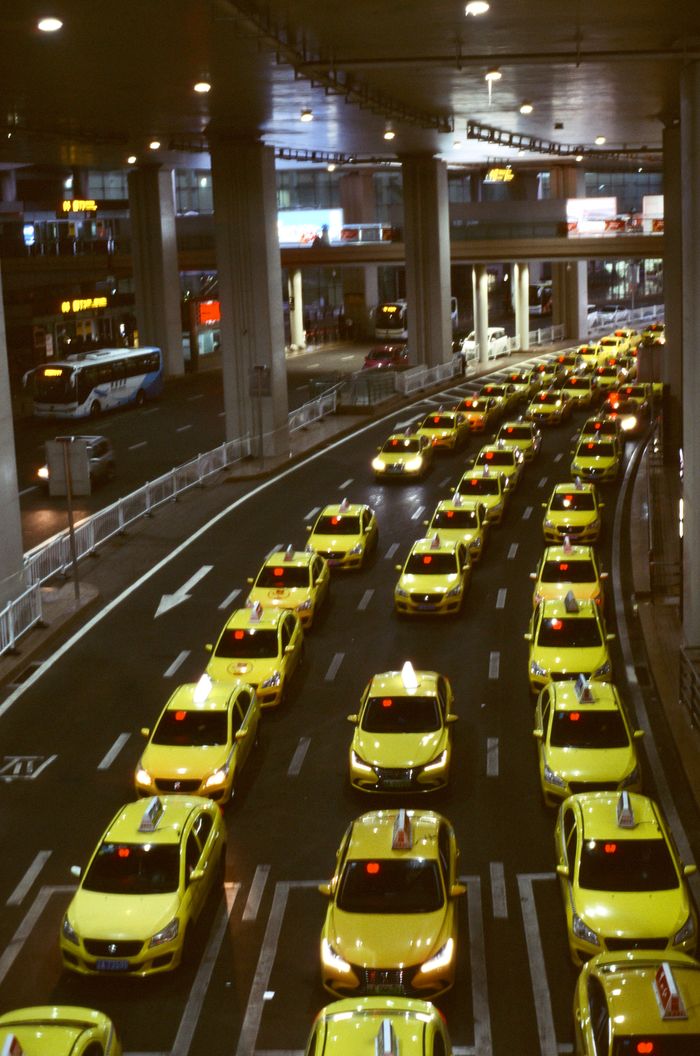 services-img Aerial view of yellow taxis in an urban setting, showcasing a busy city traffic jam at night.