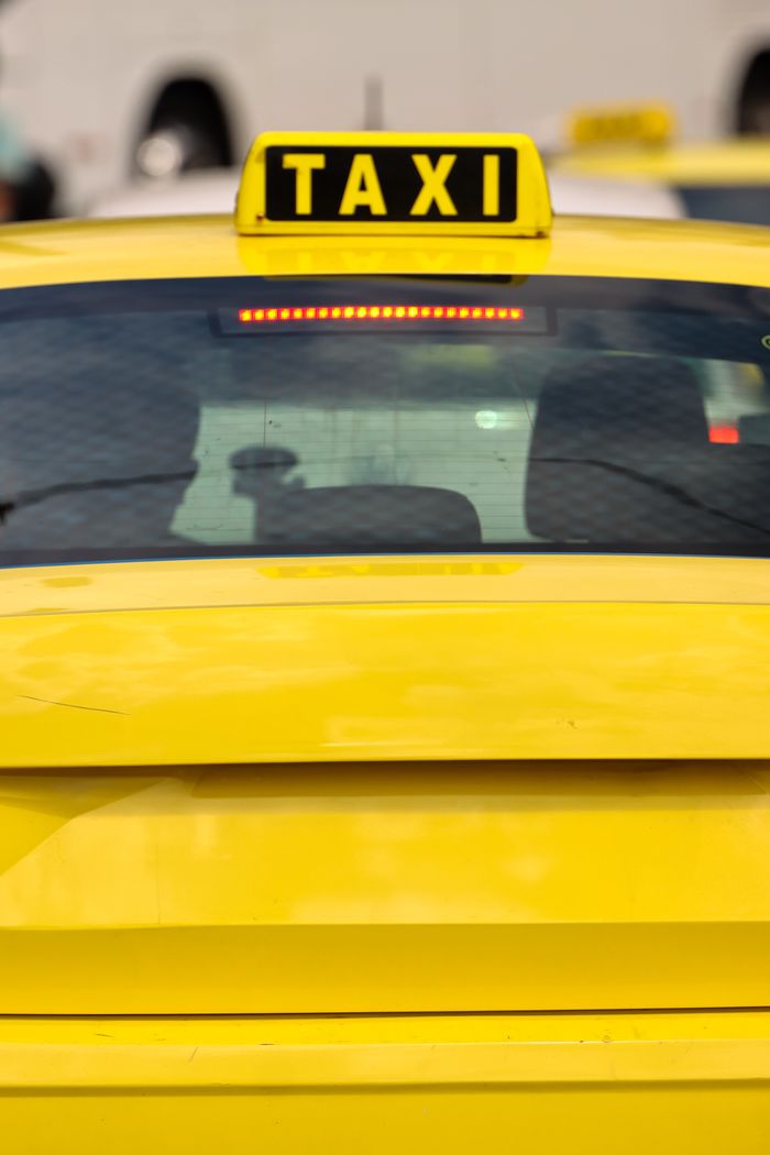 gallery-4 Close-up of a yellow taxi in Athens, Greece, highlighting the bright sign and urban setting.